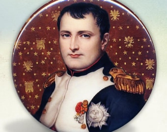 May include: A circular pinback button featuring a portrait of Napoleon Bonaparte in a dark blue and white military uniform with gold epaulettes and medals. The background is a deep red field decorated with small gold stars and bee emblems.