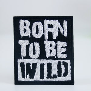 Puede incluir: Parche bordado negro con texto blanco que dice "Born to be Wild".