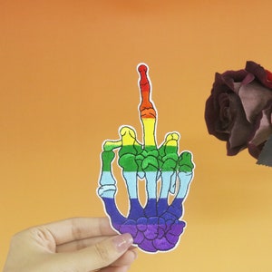 Può includere: Toppa ricamata arcobaleno di una mano scheletrica che fa il dito medio.