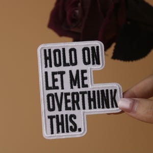 May include: White embroidered patch with black text that reads "Hold on let me overthink this."