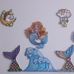 Può includere: Un set di 8 toppe da stirare con una sirena, un unicorno, una conchiglia, un'onda, una nuvola con stelle e 3 code di sirena. Le toppe sono colorate e hanno una finitura scintillante.