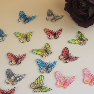 Puede incluir: Surtido de parches bordados de mariposas de colores. Los parches presentan varios colores y diseños, incluyendo azul, verde, amarillo, naranja, rosa y rojo.