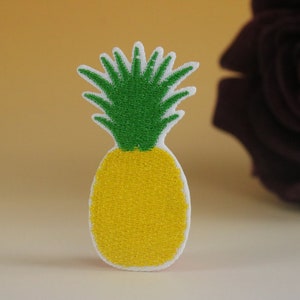 May include: A yellow and green felt pineapple appliqu&eacute; with a white outline.