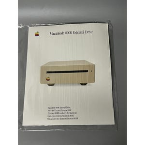 May include: A vintage Macintosh 800K External Drive, displayed on a white background. The beige-colored drive has a slot and the Apple logo. The packaging includes the text "Macintosh 800K External Drive".