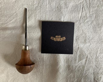 Irlandzki pierścień Claddagh, miniaturowy linoryt, złoto na czarnym tle