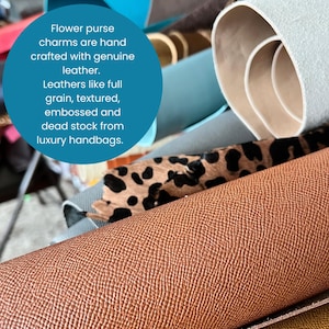 May include: A close-up of various rolls of leather in different colors and textures. The image includes a roll of brown textured leather, a roll of leather with a leopard print, and other rolls of leather in shades of blue and beige. Text in a blue circle reads: Flower purse charms are hand crafted with genuine leather.