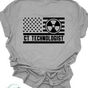 Könnte beinhalten: Ein graues T-Shirt mit einem schwarz-weißen amerikanischen Flaggen-Design. Die Flagge zeigt im Zentrum ein Strahlungssymbol und darunter den Text "CT TECHNOLOGIST".