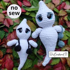 Könnte beinhalten: Zwei gehäkelte Geister-Amigurumi-Spielzeuge mit großen blauen Augen. Der kleinere Geist hat gehäkelte Arme in Schwarz. Der größere Geist hat einen gehäkelten Schwanz in Blau. Der Text "no sew" ist im Bild sichtbar.