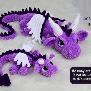 K&ouml;nnte beinhalten: Zwei geh&auml;kelte Pl&uuml;schdrachen in Lila mit wei&szlig;en Fl&uuml;geln und H&ouml;rnern. Ein Drache ist gr&ouml;&szlig;er, der andere kleiner. Die Drachen haben schwarze Augen und liegen auf einer wei&szlig;en Oberfl&auml;che. Der Text "or by two sizes" ist sichtbar.