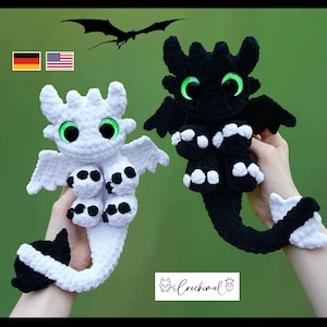 Pode incluir: Dois dragões de pelúcia feitos de fio macio. Um é branco com almofadas e ponta da cauda pretas, o outro é preto com almofadas e ponta da cauda brancas. Ambos têm olhos grandes verde-brilhantes, asas pequenas e corpo de crochê texturizado.