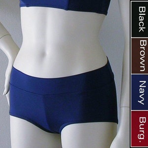 May include: Navy blue swim bottoms with a wide waistband. The bottoms are made of a smooth, stretchy fabric.