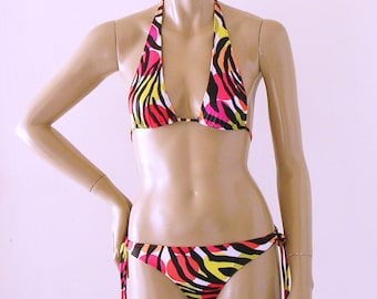 Top de bikini tipo halter deslizante y braguita brasileña con lazo en estampado de cebra Miro, disponible en tallas de top hasta copa DD.