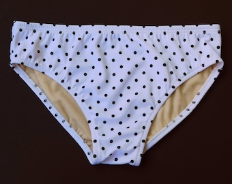 Traje de baño tipo slip para hombre, de tiro medio o bajo, en blanco y negro con estampado de lunares pequeños.
