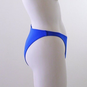 May include: Royal blue bikini bottom with a high cut leg and a low rise waist.