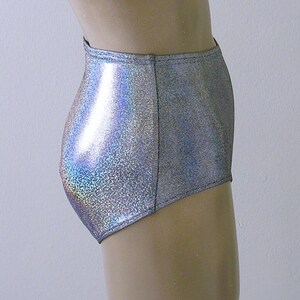 May include: High-waisted silver shorts with a shimmering, iridescent finish. The shorts are made of a shiny, reflective material and have a high-cut leg opening. The shorts are designed to be form-fitting and are likely for dance or performance wear.