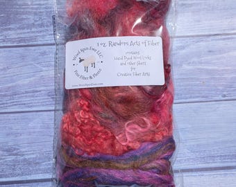 May include: A clear plastic bag containing 1 oz. of hand-dyed wool locks and fibers in shades of pink, red, purple, and brown. A white label on the front reads: 1 oz. Random Acts of Fiber, contains Hand Dyed Wool Locks and other fibers for Creative Fiber Arts, Wool Spin Ewe LLC.