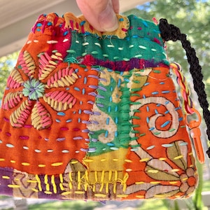 Bolso o cartera pequeña de tela con cordón, bordado a mano y confeccionado en tela reciclada intencionalmente imperfecta.
