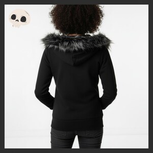 May include: Black hooded sweatshirt with a faux fur trim around the hood. The back view of the sweatshirt shows a simple, classic design. The model is wearing dark wash jeans. The sweatshirt is a versatile piece for casual wear.
