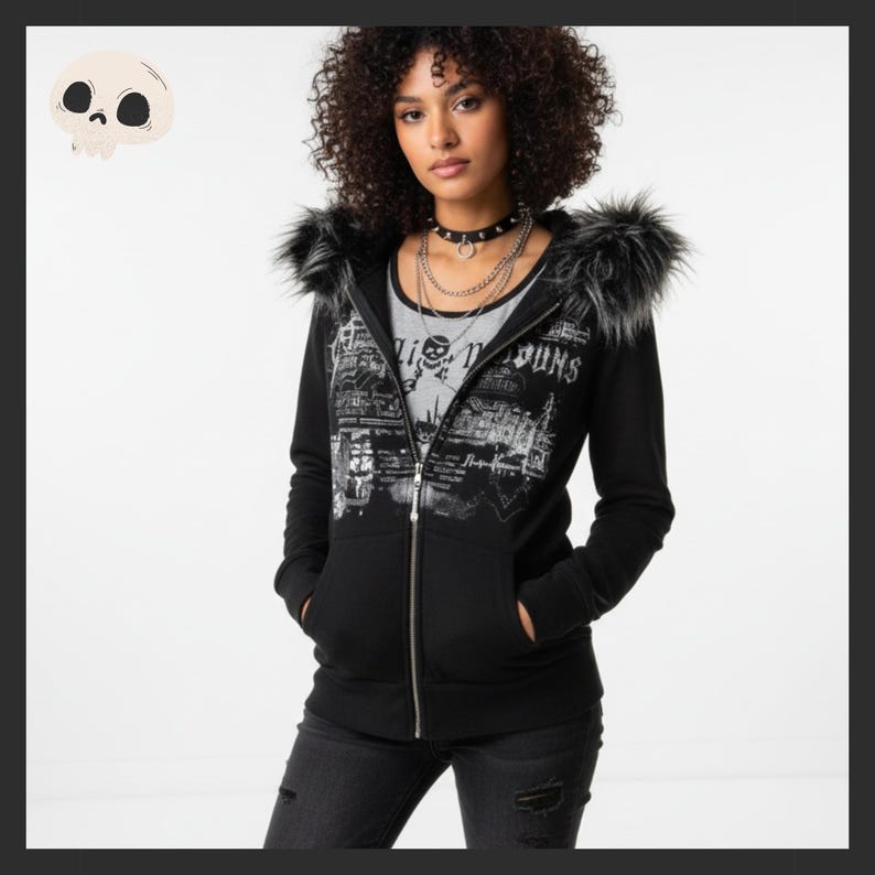 May include: Black zip-up hoodie with faux fur trim on the hood. The hoodie features a graphic print with the text "Living Weapons" and a skull design. The model is wearing a gray t-shirt underneath the hoodie.