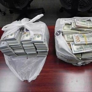 K&ouml;nnte beinhalten: Zwei wei&szlig;e Plastikt&uuml;ten gef&uuml;llt mit Stapeln von US-Dollar-Scheinen. Die Scheine sind mit Gummib&auml;ndern geb&uuml;ndelt und einige sind mit der Nummer "100" gekennzeichnet.