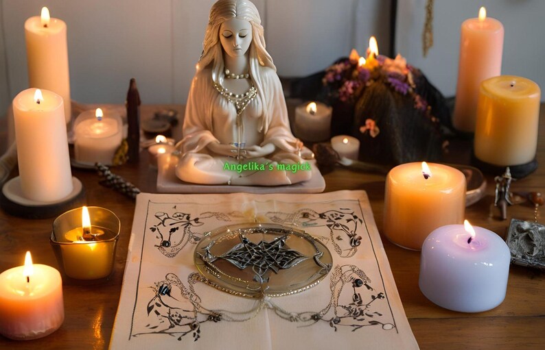 K&ouml;nnte beinhalten: Eine wei&szlig;e Keramikfigur einer Frau, die in meditativer Haltung mit den H&auml;nden im Scho&szlig; sitzt. Die Figur ist umgeben von brennenden Kerzen, einem Buch und anderen Dekorationsgegenst&auml;nden. Der Text "Angelika's Magick" ist auf dem Buch zu sehen.