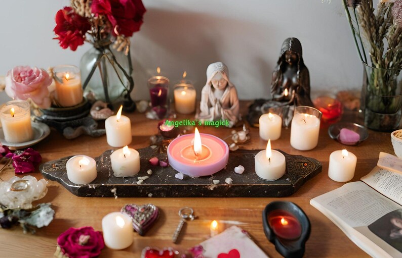 Pu&ograve; includere: Un tavolo con una variet&agrave; di candele bianche, una candela rosa e un portacandele rosa. Ci sono anche fiori, un libro e altri oggetti decorativi sul tavolo.