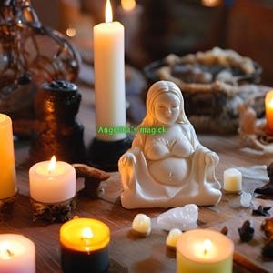 Pu&ograve; includere: Una statuetta in ceramica bianca di una donna incinta seduta con le mani sul ventre. La statuetta &egrave; circondata da candele accese, cristalli e altri oggetti spirituali. Il testo "Angela's magick" &egrave; visibile nell'immagine.