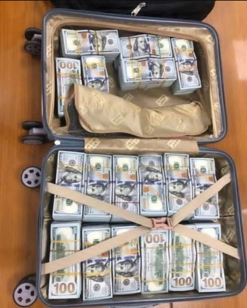 K&ouml;nnte beinhalten: Ein Koffer voller Stapel von US-Dollar-Scheinen im Wert von 100 Dollar, die mit Gurten gesichert sind. Die Scheine sind ordentlich angeordnet und in Reihen gestapelt.