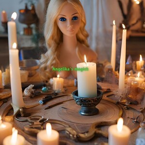 K&ouml;nnte beinhalten: Ein wei&szlig;er Porzellandollenkopf mit blonden Haaren sitzt in der Mitte eines Holztisches mit brennenden Kerzen, die in einem Kreis um ihn herum angeordnet sind. Die Kerzen sind in verschiedenen Gr&ouml;&szlig;en und Stilen, und es gibt andere dekorative Gegenst&auml;nde auf dem Tisch, darunter Kristalle und eine kleine Schale. Der Text "Angelika's magic" ist auf dem Tisch vor der Puppe geschrieben.