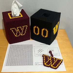 May include: Two handmade tissue box covers, one burgundy and one black, with gold accents. The burgundy box features a gold "W", and the black box has gold "00" and "W" designs. A small burgundy and gold "W" is also present.
