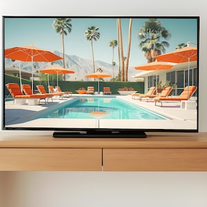May include: A black flat screen television displaying a picture of a swimming pool with orange lounge chairs and umbrellas. The pool is surrounded by palm trees and a mountain range in the background.