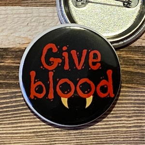 Give Blood Vampire fangs Pin back button badge. Great to wear for Halloween. 2 sizes available. Great gift for nurses and phlebotomists