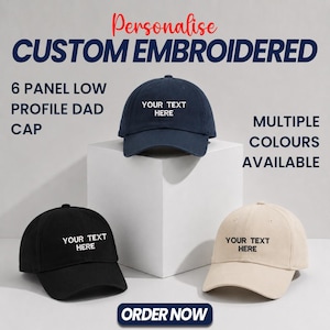 Peut inclure: Trois casquettes à six panneaux et profil bas en bleu marine, noir et beige, chacune avec le texte brodé blanc YOUR TEXT HERE. L'image contient le texte Personalise CUSTOM EMBROIDERED 6 PANEL LOW PROFILE DAD CAP, MULTIPLE COLOURS AVAILABLE et ORDER NOW.