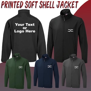 Könnte beinhalten: Fünf Softshelljacken in verschiedenen Farben. Die Jacken sind schwarz, grün, marineblau und grau. Jede Jacke hat einen Reißverschluss und einen Stehkragen. Die Jacken sind alle mit dem Text "Your Text or Logo Here" personalisiert.