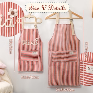 May include: Red and white striped aprons, one adult size (37.4in/95cm) and one child size (20in/51cm), hang on a wall. The aprons have pockets and the text "Olivia" is embroidered on the child's apron. The adult apron has the text "kitchen cooking" on the pocket.