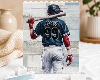 Puede incluir: Un bloque rectangular que muestra a un jugador de béisbol visto desde atrás, con una camiseta azul oscuro con el nombre JAMES y el número 99 en blanco, casco negro y guantes de bateo rojos, sosteniendo un bate de madera sobre los hombros.