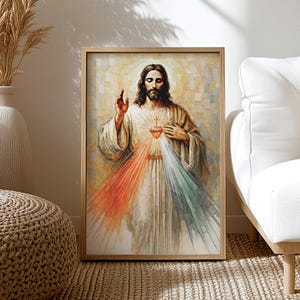 May include: A framed print of a religious figure with long brown hair and a beard, wearing a white robe. The figure has a glowing heart on their chest, with red, white, and green rays emanating from it. The artwork is in a wooden frame.