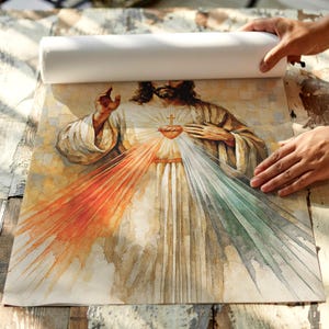 May include: A religious print depicting a figure with a glowing heart and rays of orange, white, and green light emanating from it. The figure is wearing a white robe and has a cross on their chest. The print is being unrolled.
