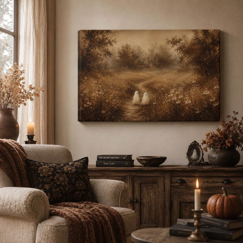 Puede incluir: Un lienzo rectangular con una pintura de paisaje en tonos sepia que muestra un sendero forestal con dos peque&ntilde;as figuras de fantasmas blancos en un campo de flores silvestres, exhibido en una habitaci&oacute;n con sill&oacute;n, mueble y velas.