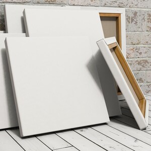 May include: A stack of blank white canvases with wooden frames. The canvases are leaning against a brick wall.