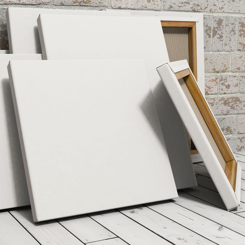 May include: A stack of blank white canvases with wooden frames. The canvases are leaning against a brick wall.