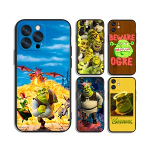 May include: A selection of phone cases showcasing Shrek characters and scenes. Designs include Shrek with Donkey, a dragon, and the text "BEWARE OGRE". Cases have a glossy finish and various background colours.