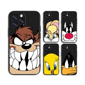 May include: Black phone cases featuring Looney Tunes characters. The cases display Taz, Lola Bunny, Sylvester, Tweety Bird, and Daffy Duck. Each case has a black border and a colorful cartoon character design.
