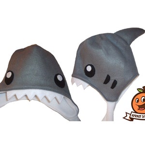 May include: Gray felt shark hat with white felt teeth and black felt eyes. The hat has a fin on top and a white felt lining. The hat is a DIY pattern from Aprikot DIY Patterns.