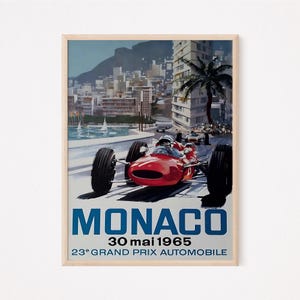 May include: A vintage poster advertising the 23rd Monaco Grand Prix, held on May 30, 1965. The poster features a red race car speeding through the streets of Monaco, with the city skyline and the Mediterranean Sea in the background.
