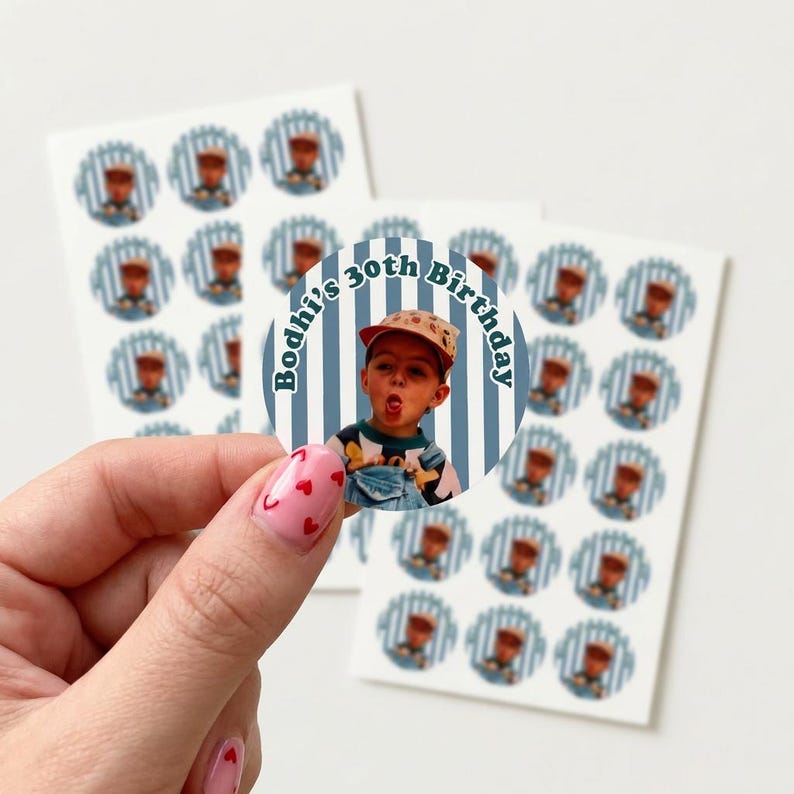 May include: A sheet of stickers featuring a photo of a person wearing a cap and overalls, with the text "Bodhi's 30th Birthday." The stickers have a blue and white striped background. Additional stickers with a similar design are visible.
