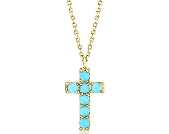 May include: A gold-colored necklace featuring a cross pendant. The cross is adorned with five round, light blue gemstones. The chain is delicate and also gold-colored, creating a simple yet elegant design.