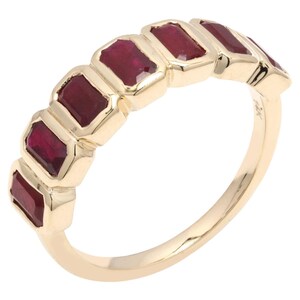 May include: A gold ring with a row of rectangular, deep red gemstones. The gemstones are set in individual bezels, forming a continuous line. The band is plain, polished gold. The ring is a classic design.