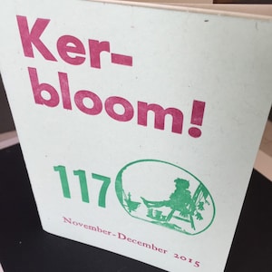 May include: A green and pink magazine cover with the title "Ker-bloom!" and the issue number "117" printed on it. The cover also includes the text "November-December 2015" and a green illustration of a person sitting on a chair.