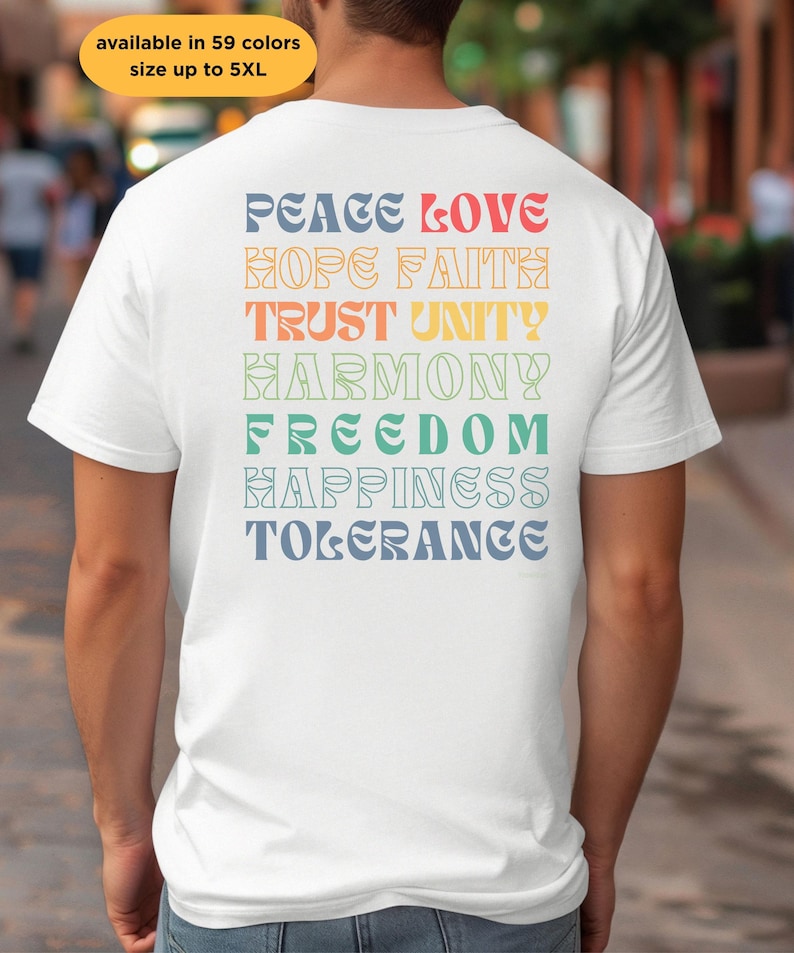 May include: White t-shirt with a rainbow gradient design featuring the words "Peace Love Hope Faith Trust Unity Harmony Freedom Happiness Tolerance" printed on the back.
